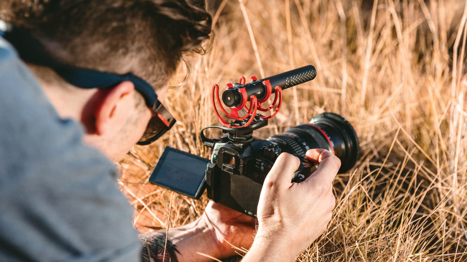 Man with VideoMic NTG on camera filming from low angle