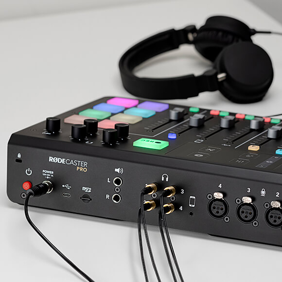 Four HJA-4s connected to back of RØDECaster Pro with headphones in background