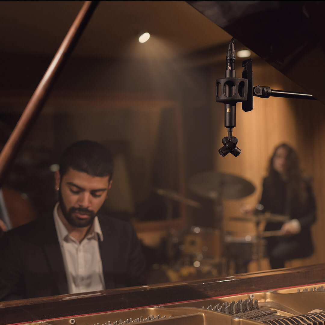 NT-SF1 over piano being played by man with drummer in background