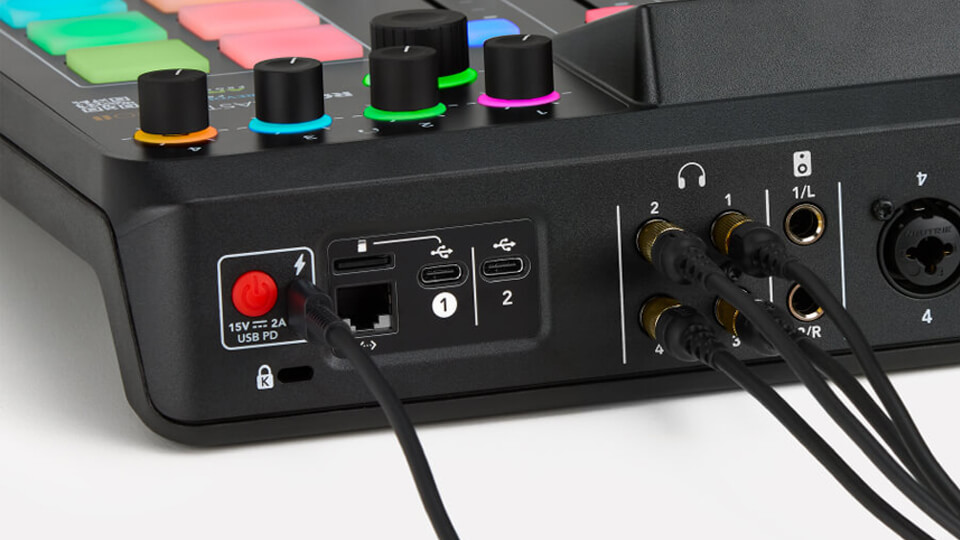 RØDECaster Pro II on white desk with NTH-100 and PodMic