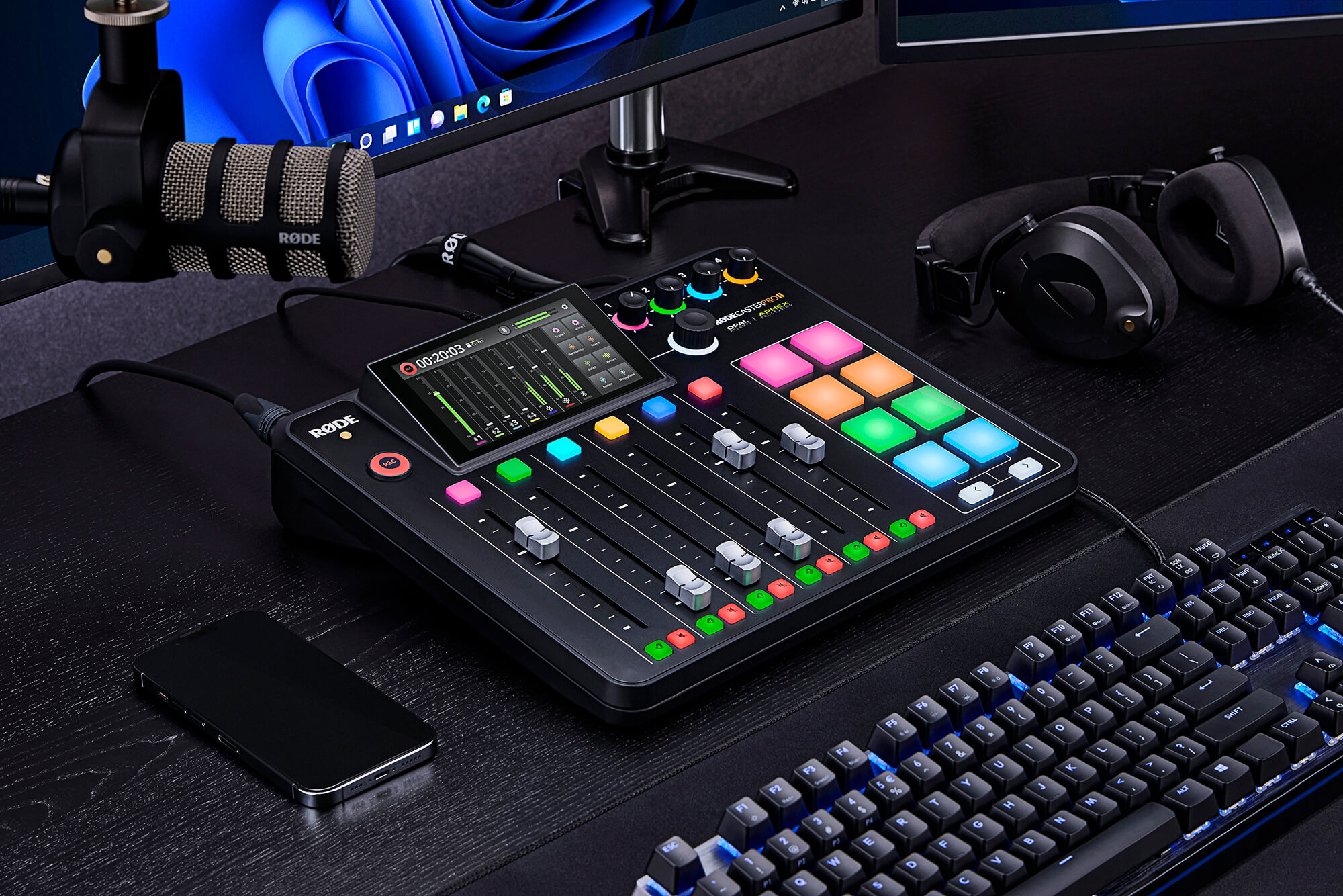 RØDECaster Pro II with NTH-100, PodMic, mobile phone, keyboard and computer screen nearby