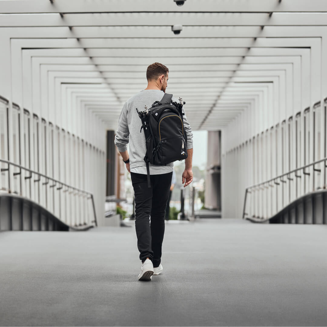Man wearing Backpack walking through bridge