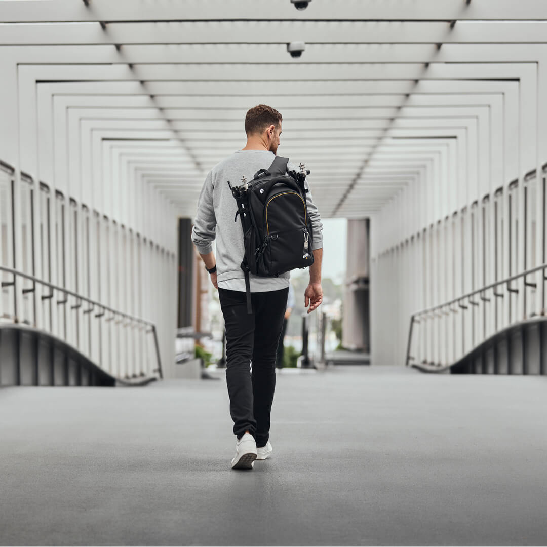 Uomo che indossa uno zaino che cammina attraverso il ponte