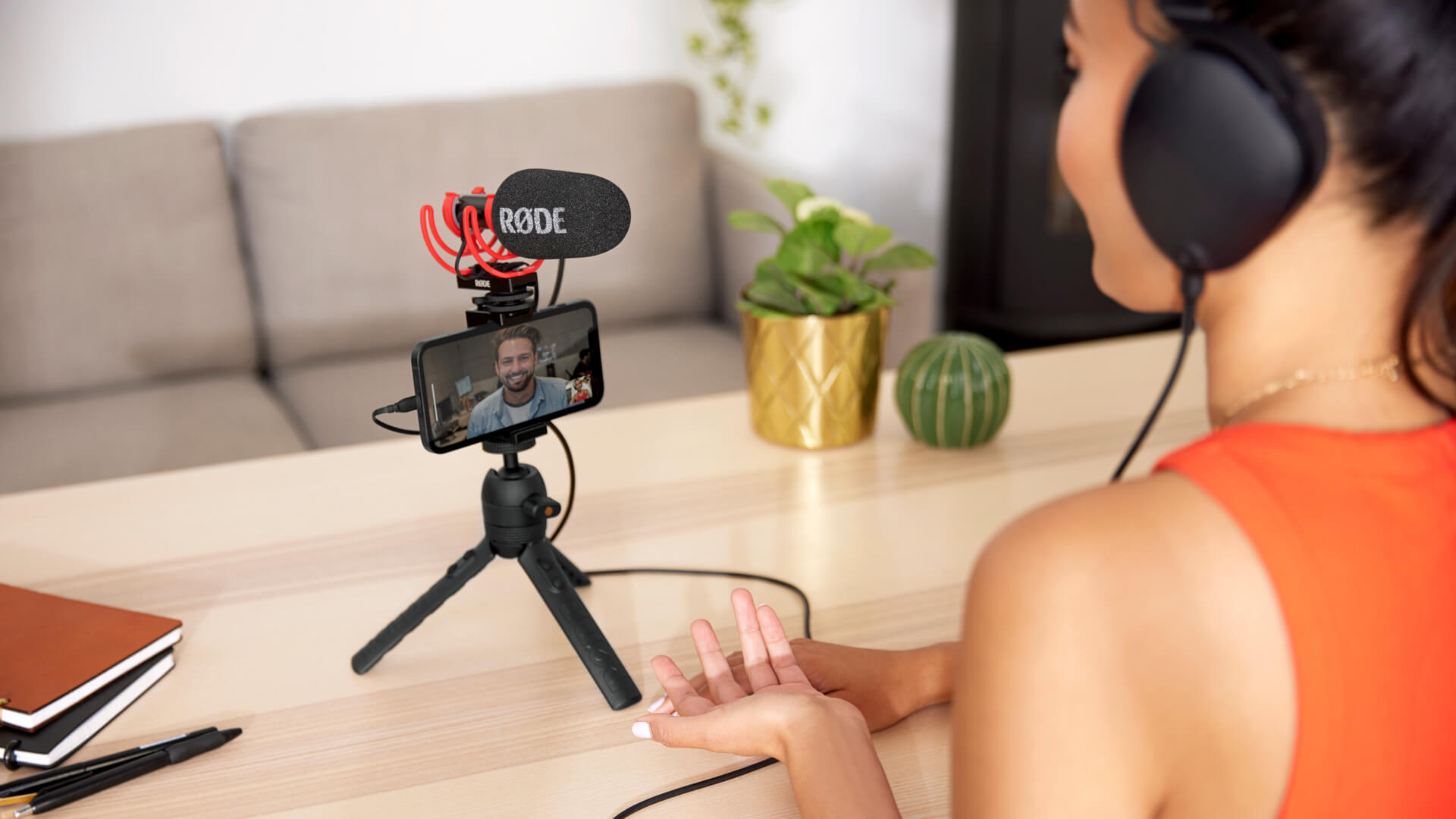 Cô gái đeo NTH-100 sử dụng VideoMic GO II với điện thoại di động trên Tripod 2