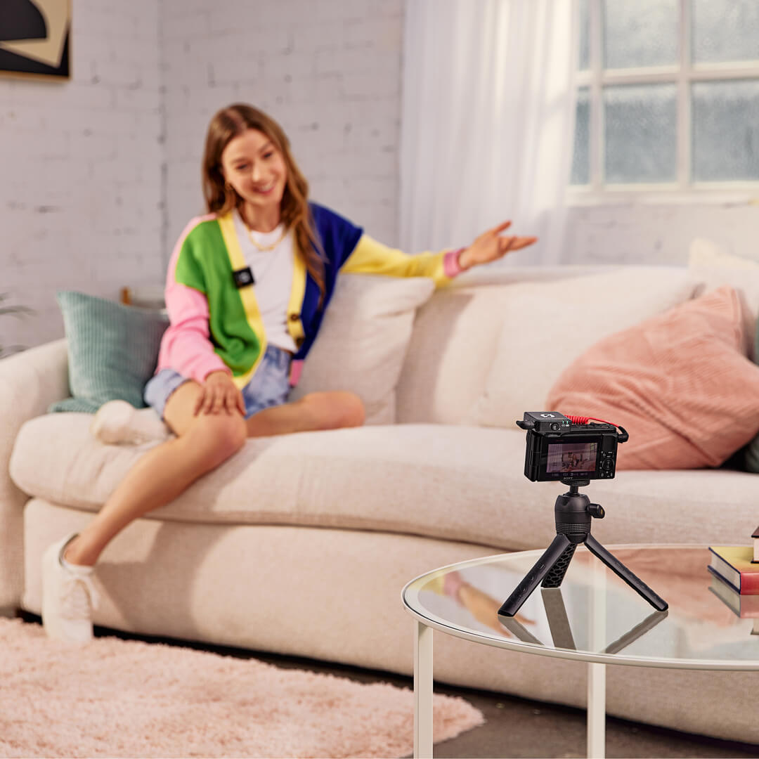 Tyttö olohuoneessa tallentaa Wireless Me -sovelluksella ja kamera jalustalla