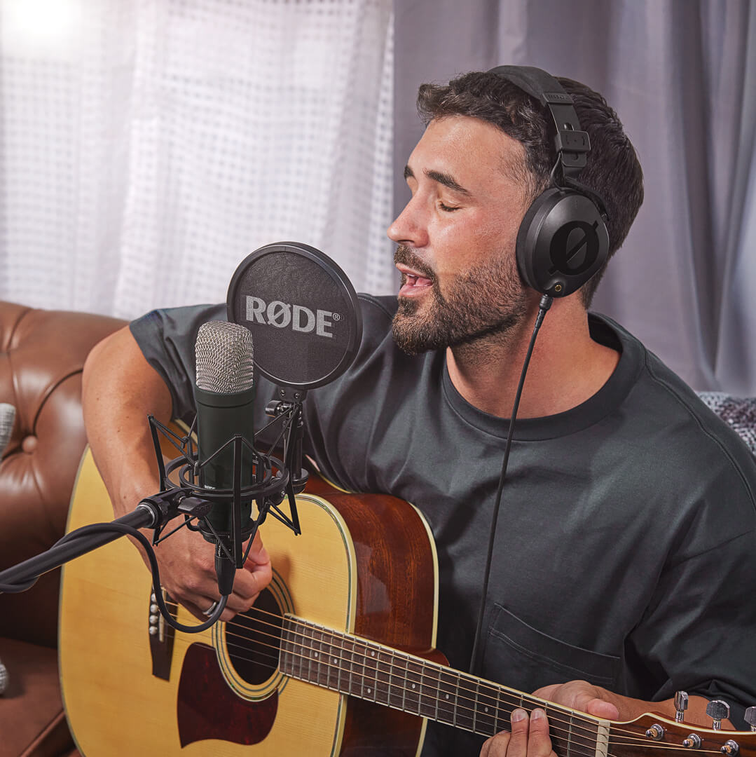 Hombre grabando guitarra y voz con NT1 Signature Series negro